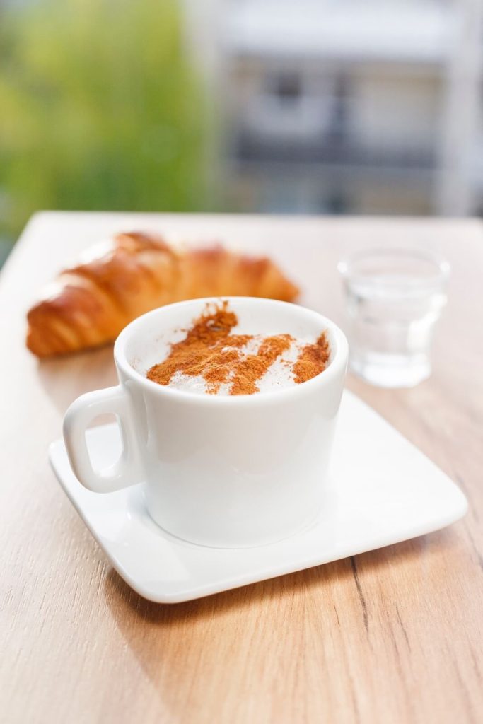 Pumpkin spice coffee and croissant on table